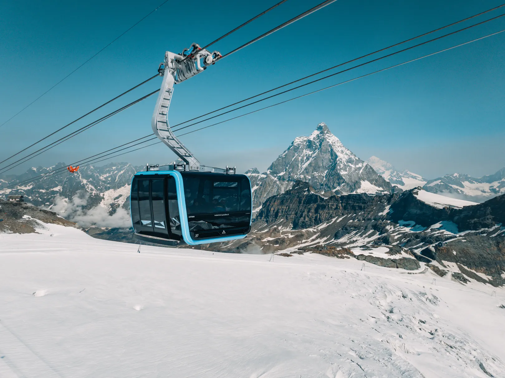 The Matterhorn Glacier Ride gondola floats over a high-alpine glacier landscape near Zermatt.